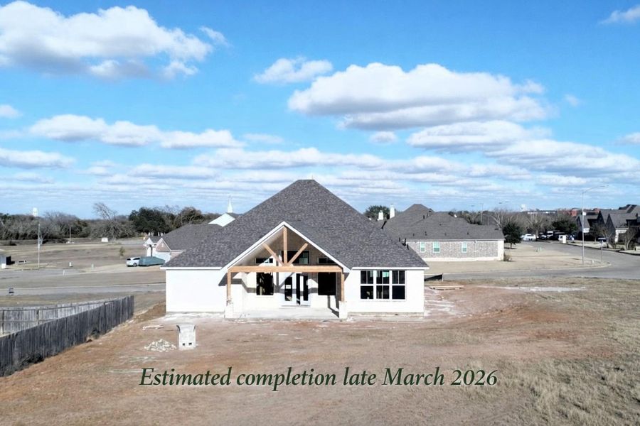 Rear exterior view with spacious backyard. Estimated completion late March 2026.