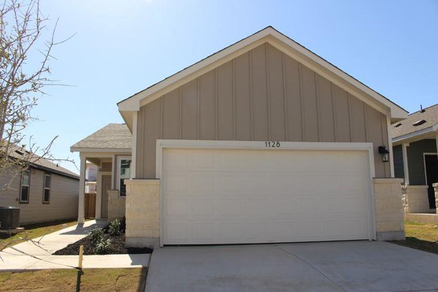 Ranch-style house with an attached garage, cooling unit, board and batten siding, and driveway