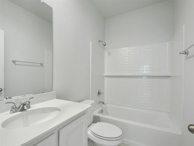 Full bathroom featuring vanity, toilet, and shower / bathtub combination Full bathroom featuring vanity, toilet, and shower / bathtub combination