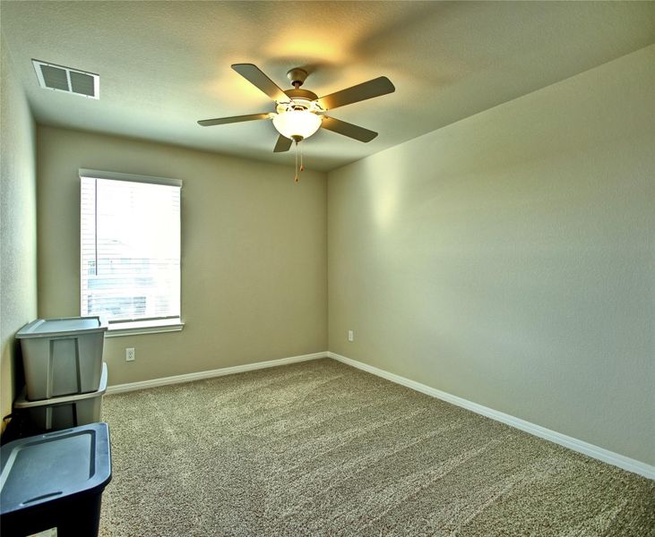 Carpeted empty room with ceiling fan and a textured ceiling Carpeted empty room with ceiling fan and a textured ceiling
