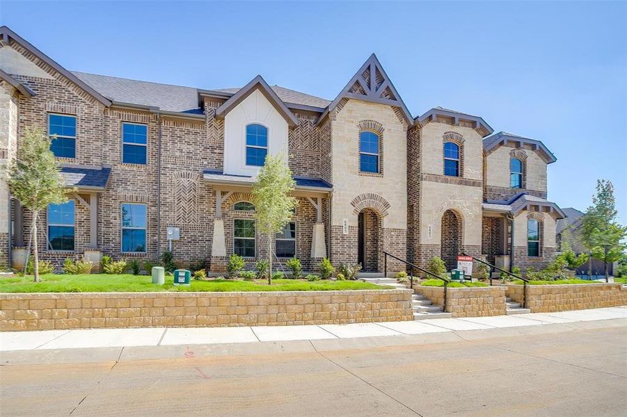 View of front of property featuring brick siding, a shingled roof, and stone siding View of front of property featuring brick siding, a shingled roof, and stone siding