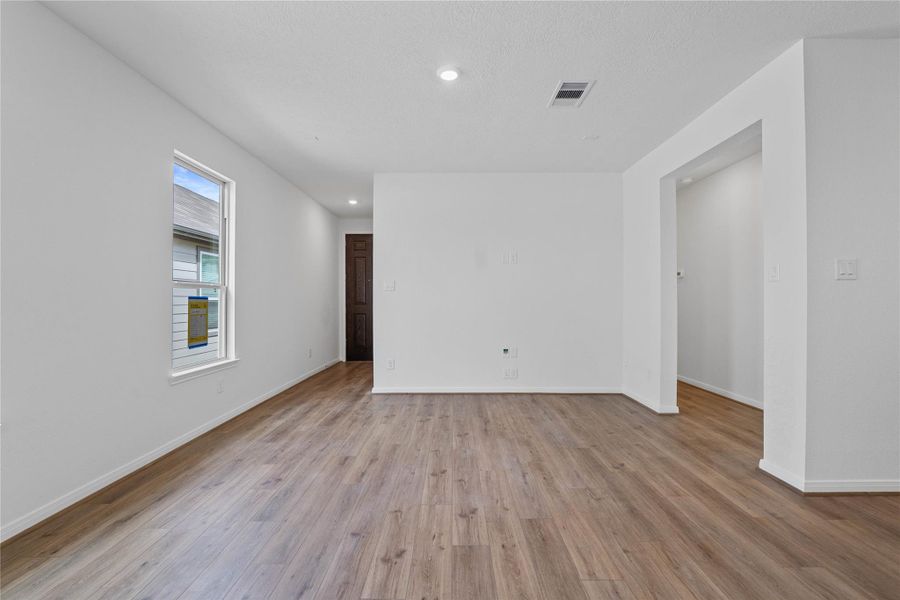 Step inside your new home, where the Layton Lake Wild Dunes vinyl plank flooring and fresh, bright paint create a warm and inviting entryway.