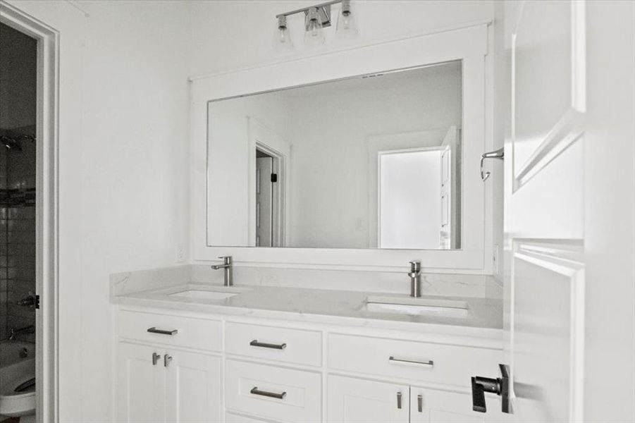Full bath with double vanity and toilet