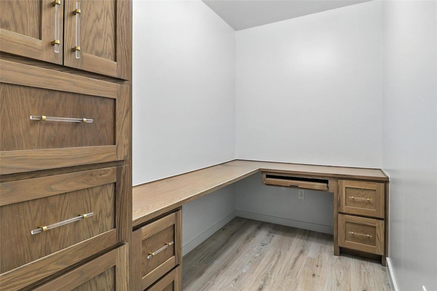 Unfurnished office featuring built in study area and light wood-type flooring