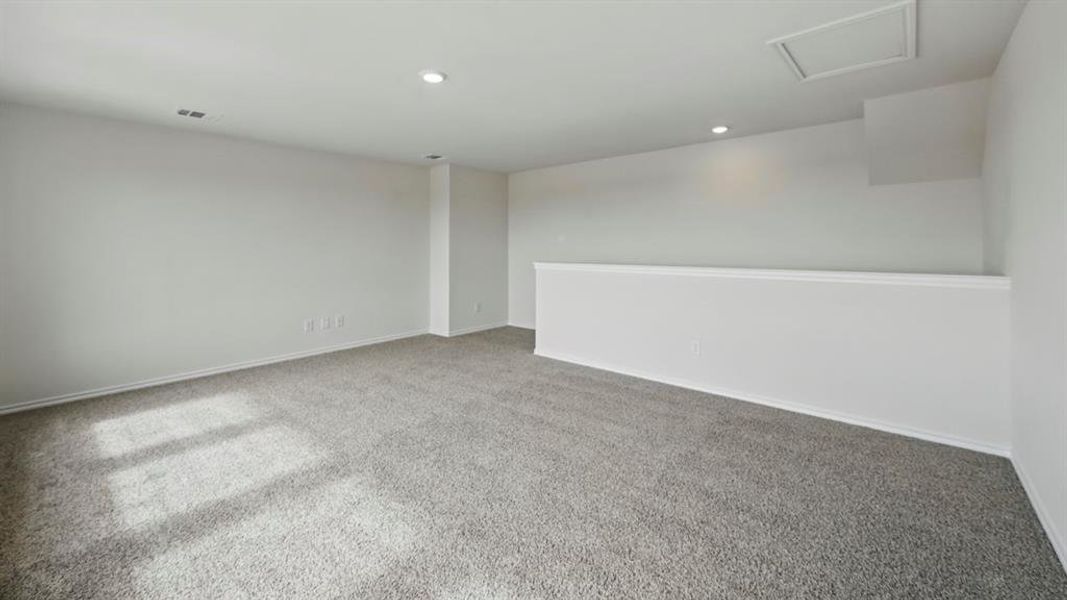 Carpeted empty room with recessed lighting and attic access