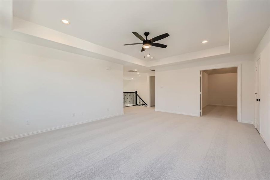 Game room with ceiling fan and a raised ceiling