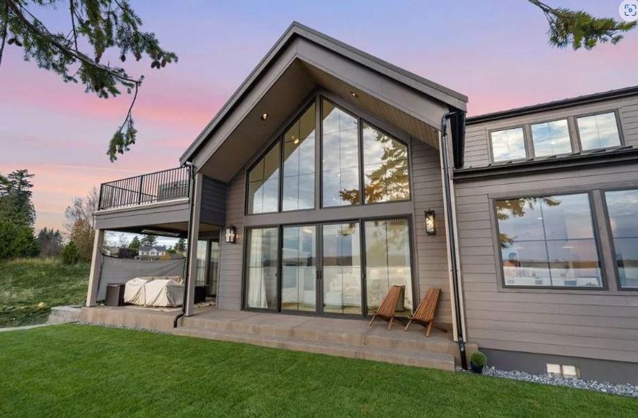 Back of house at dusk featuring Covered Patios and Upper deck