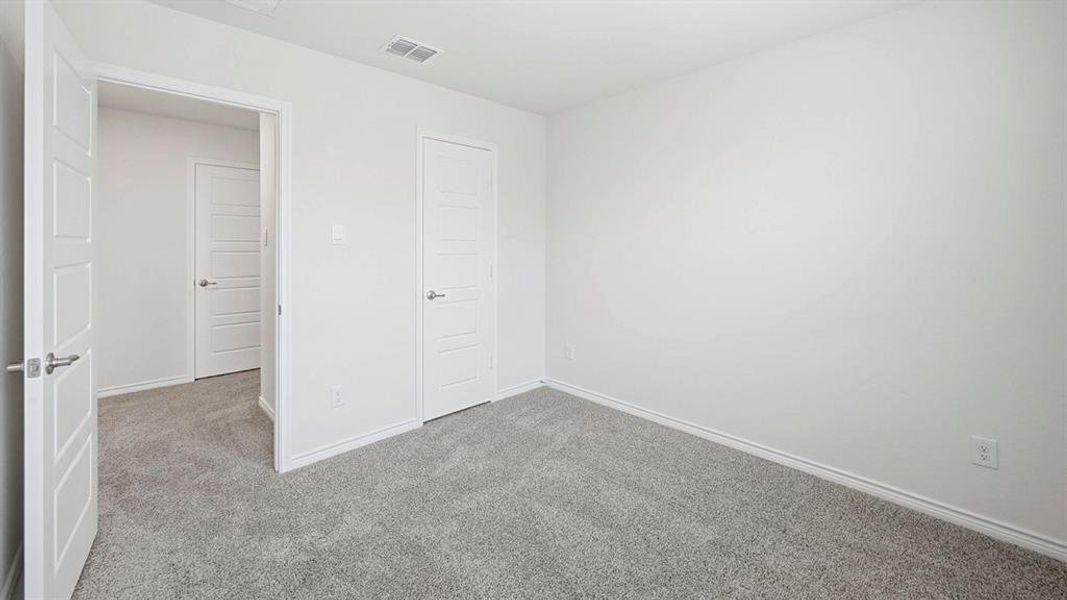Spacious room featuring light gray carpet flooring and white painted walls