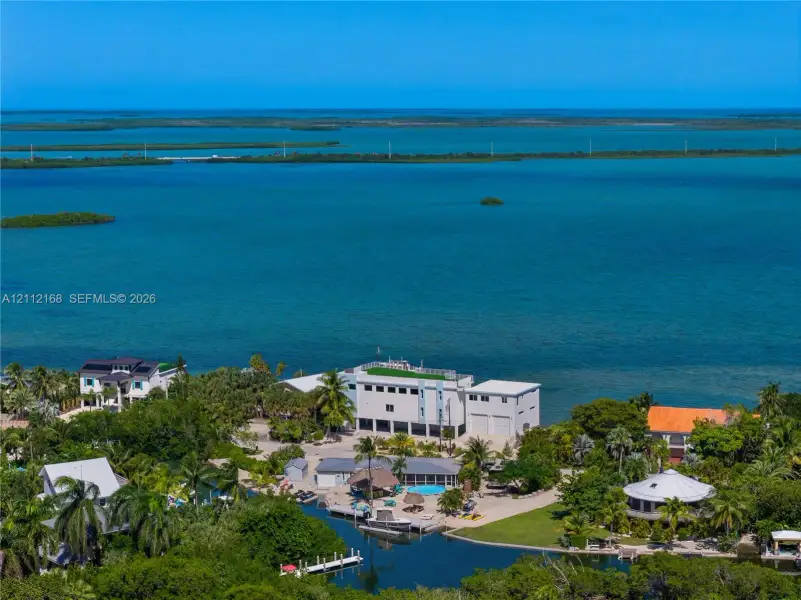Waterfront property featuring a private boat dock, swimming pool, and direct canal access, situated on a lot with mature tropical landscaping Waterfront property featuring a private boat dock, swimming pool, and direct canal access, situated on a lot with mature tropical landscaping