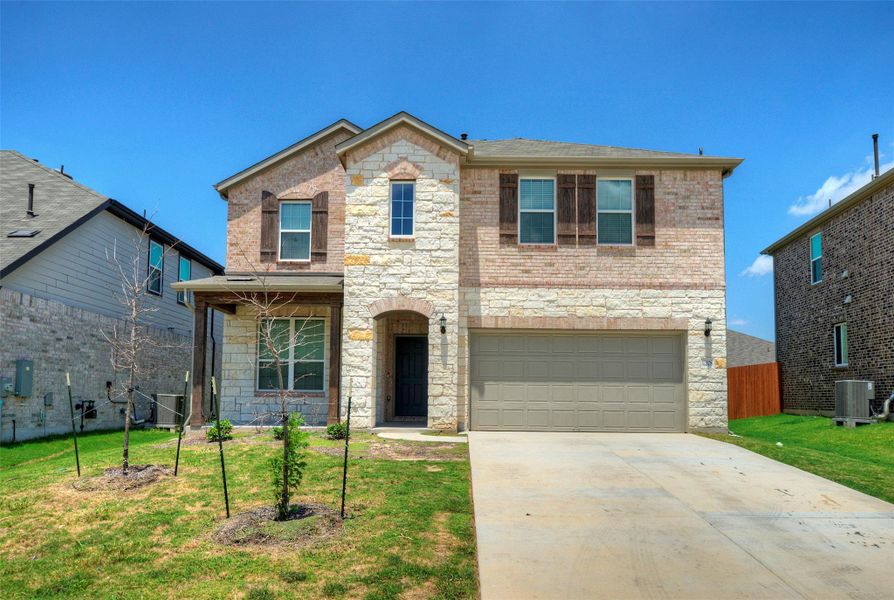 A charming two-story home with a brick and stone facade, showcasing a well-kept front yard and an attached garage. A charming two-story home with a brick and stone facade, showcasing a well-kept front yard and an attached garage.