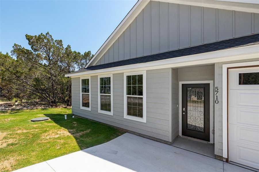 Property entrance featuring a garage and a yard