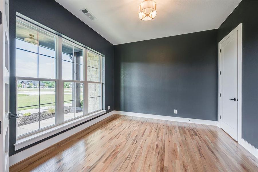 Unfurnished room featuring light wood finished floors and baseboards