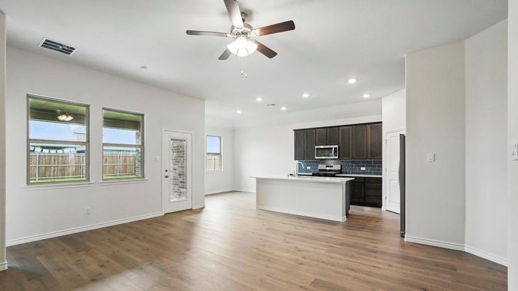 Open-concept living space featuring wood-finish flooring, recessed lighting, and a ceiling fan