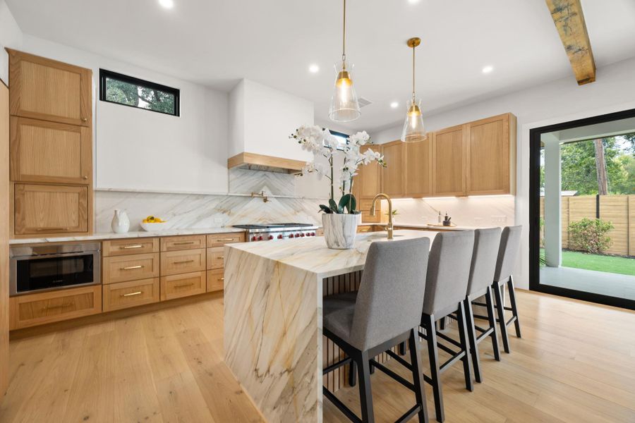 Gleaming hardwood floors and striking stone countertops define this elegant culinary space.