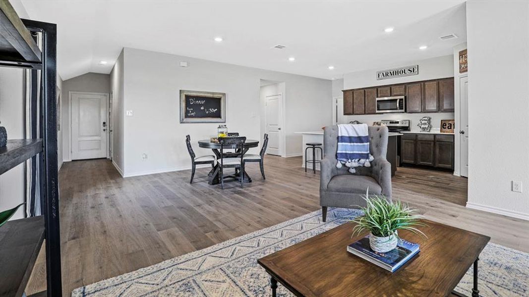 Open concept living area featuring wood-finish flooring, recessed lighting, and a neutral color palette
