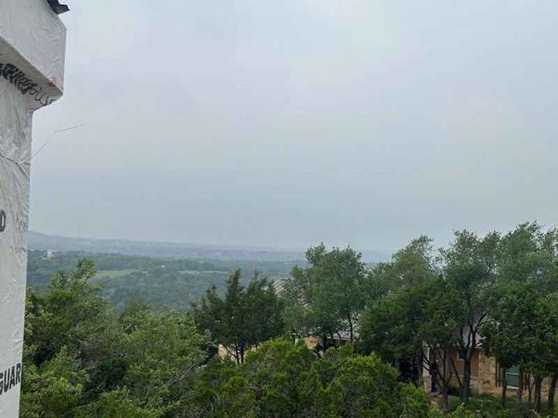 Expansive distant landscape featuring lush tree canopy and distant structures Expansive distant landscape featuring lush tree canopy and distant structures
