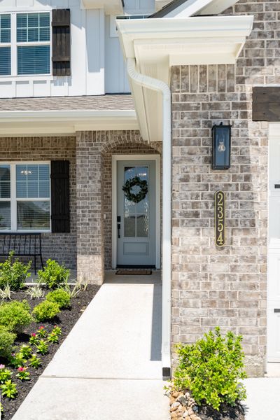 Front exterior of a new home in Greens Prairie Reserve, College Station, TX, highlighting curb appeal (Image 20).