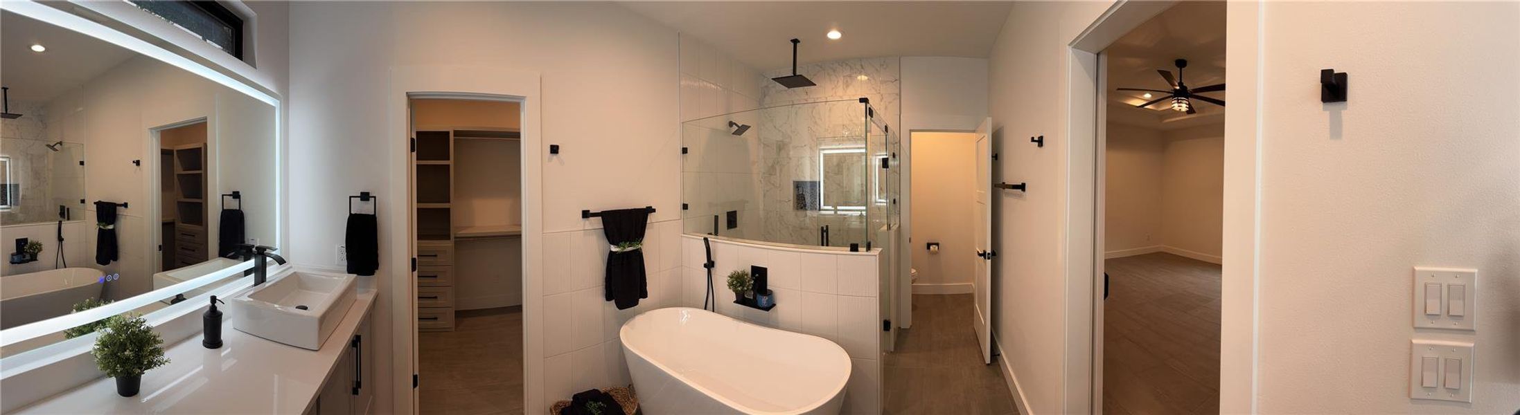 Full bathroom with a walk in closet, a stall shower, vanity, a freestanding tub, and recessed lighting Full bathroom with a walk in closet, a stall shower, vanity, a freestanding tub, and recessed lighting