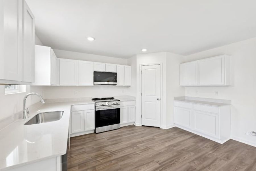 A kitchen with white cabinets.