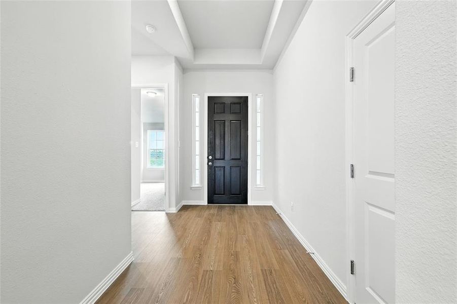 Entrance foyer with wood finished floors and a textured wall