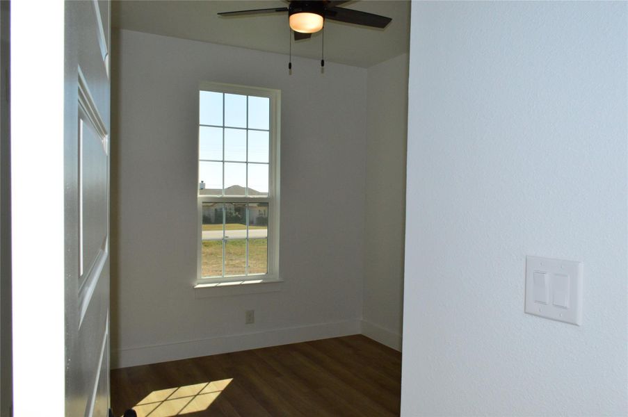 Spare room with dark wood-style floors and a ceiling fan Spare room with dark wood-style floors and a ceiling fan