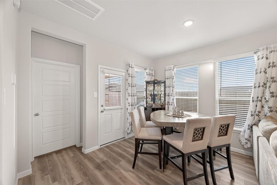 Forget dark corners; this dining area is wrapped in windows and sits right by the patio door for effortless indoor-outdoor hosting.