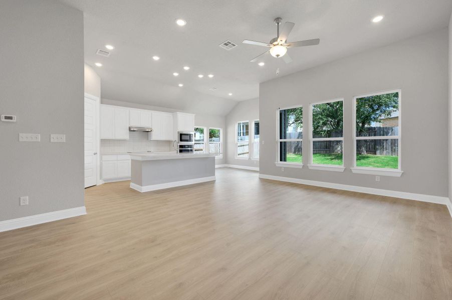 Unfurnished living room with recessed lighting, vaulted ceiling, ceiling fan, and light wood finished floors