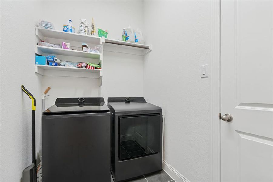 Laundry room featuring washer and dryer and tile patterned flooring Laundry room featuring washer and dryer and tile patterned flooring
