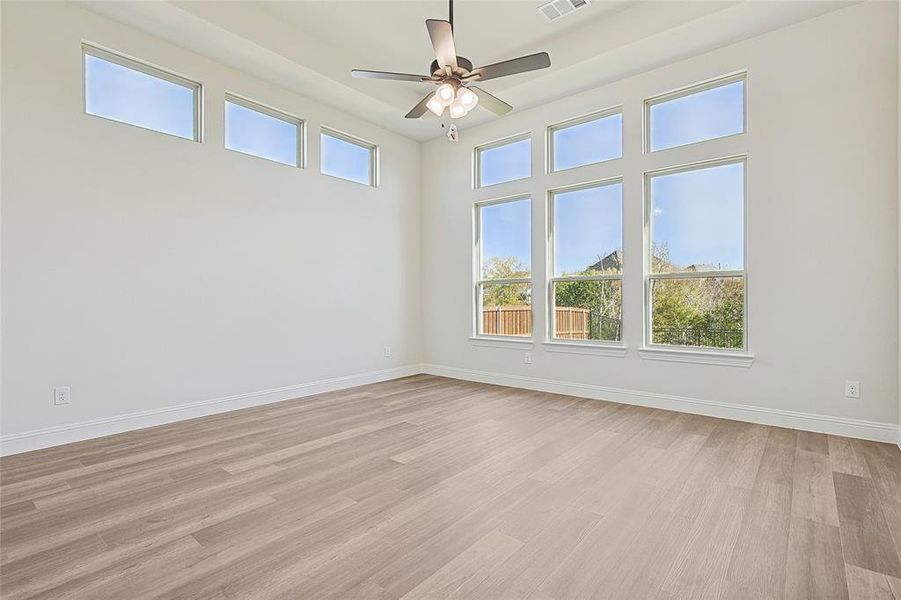 Empty room with plenty of natural light and light hardwood / wood-style floors