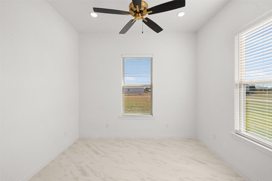 Spare room featuring a ceiling fan, recessed lighting, and light marble finish floors