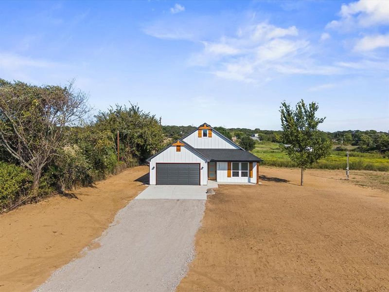 Modern inspired farmhouse with driveway, a garage, and board and batten siding