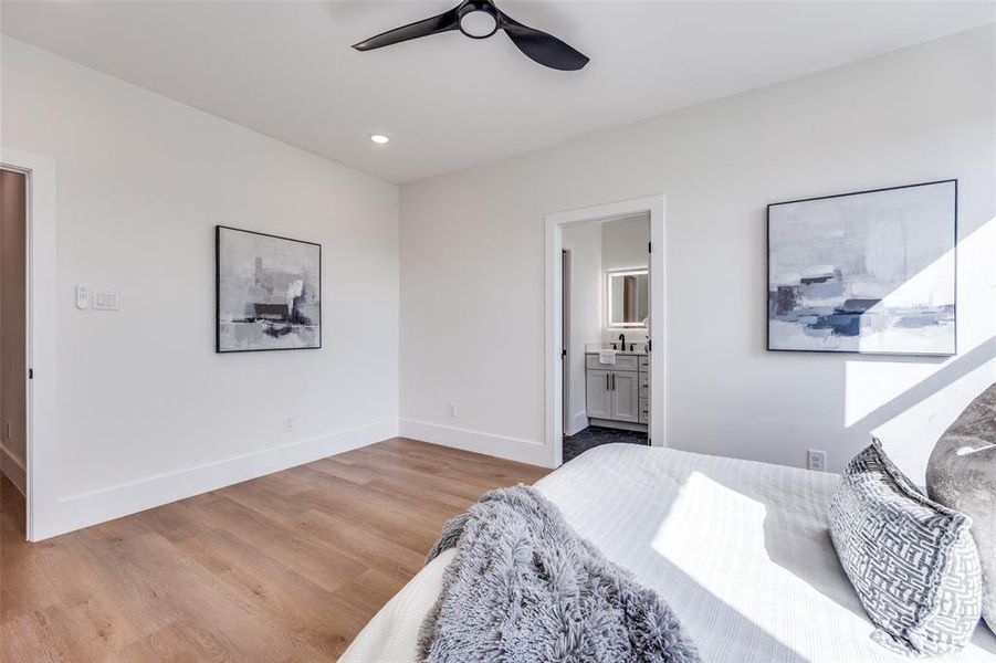 Bedroom with light wood-type flooring, ensuite bath, recessed lighting, and ceiling fan Bedroom with light wood-type flooring, ensuite bath, recessed lighting, and ceiling fan