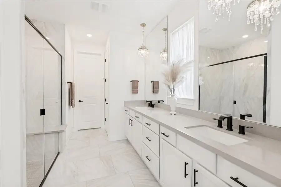 Gleaming marble tile floors and sleek stone counters define this modern master bath layout.