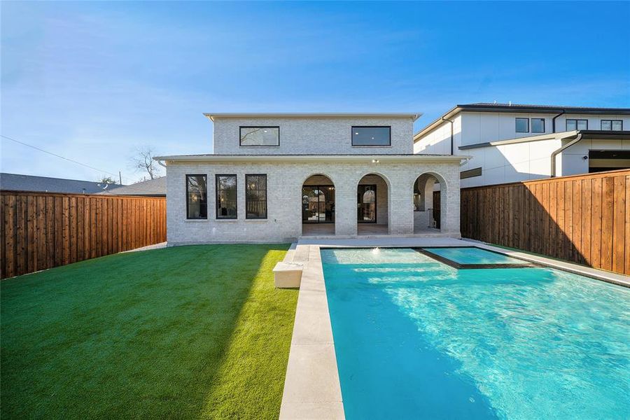 Back of house featuring a patio, a fenced backyard, brick siding, and a pool with connected hot tub Back of house featuring a patio, a fenced backyard, brick siding, and a pool with connected hot tub
