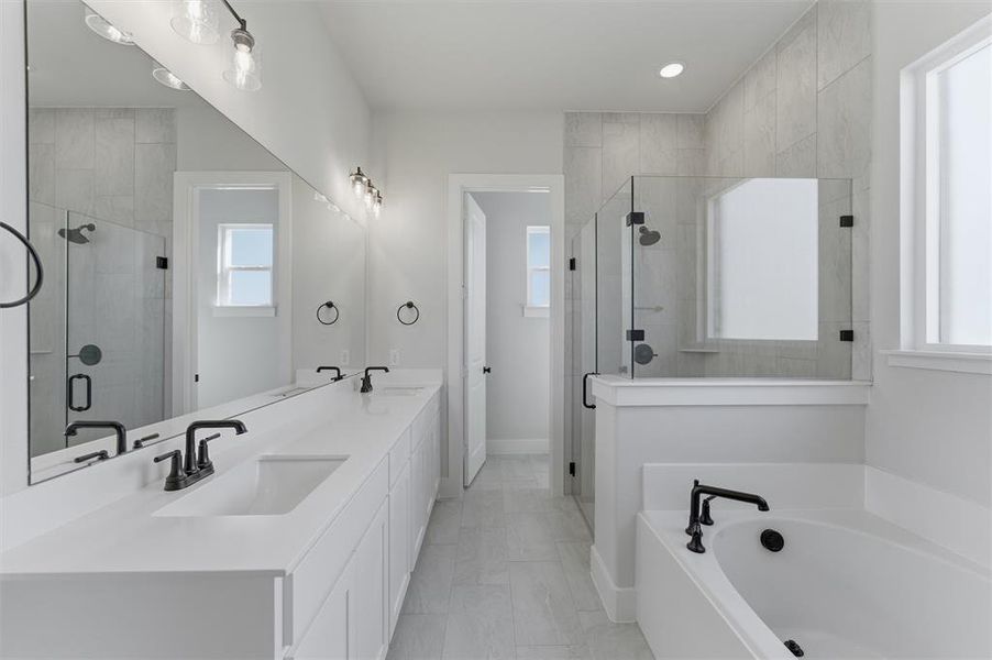 Bathroom featuring double vanity, a shower stall, a garden tub, and recessed lighting