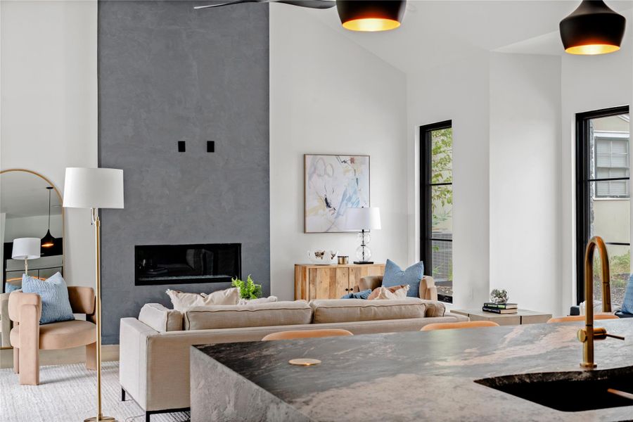 Living area with a high end fireplace and a high ceiling