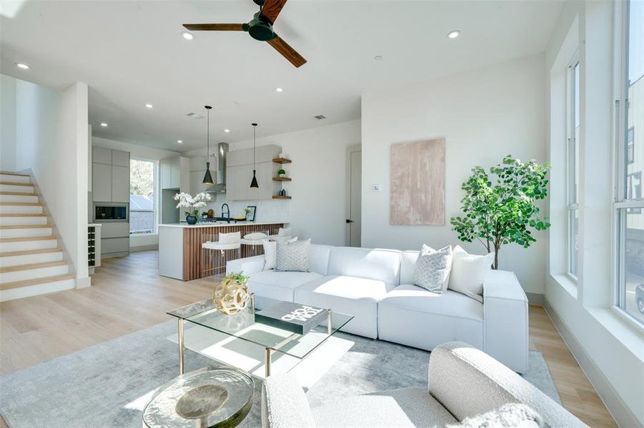 Living room featuring light hardwood / wood-style floors, ceiling fan, and sink