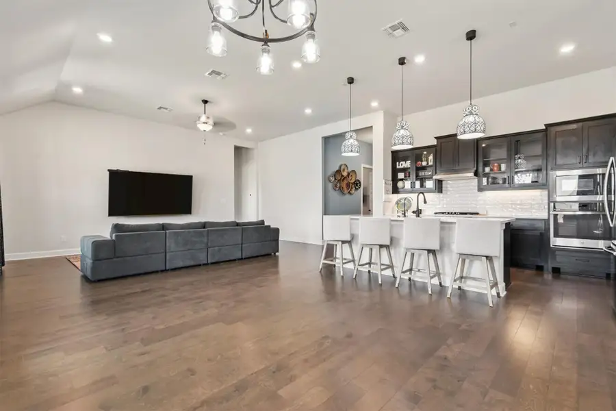 Dining area with dark wood-style floors, a chandelier, recessed lighting, and lofted ceiling Dining area with dark wood-style floors, a chandelier, recessed lighting, and lofted ceiling