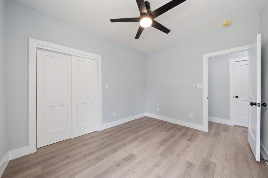 Interior space featuring wood-finish flooring, light grey walls, and white baseboards