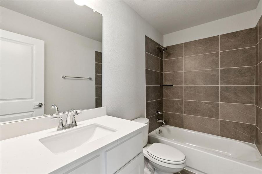 Full bathroom featuring tub / shower combination, vanity, and a textured wall Full bathroom featuring tub / shower combination, vanity, and a textured wall