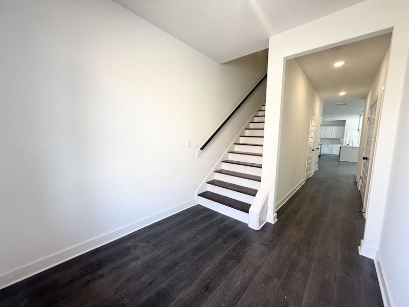 Stairway featuring wood finished floors and recessed lighting