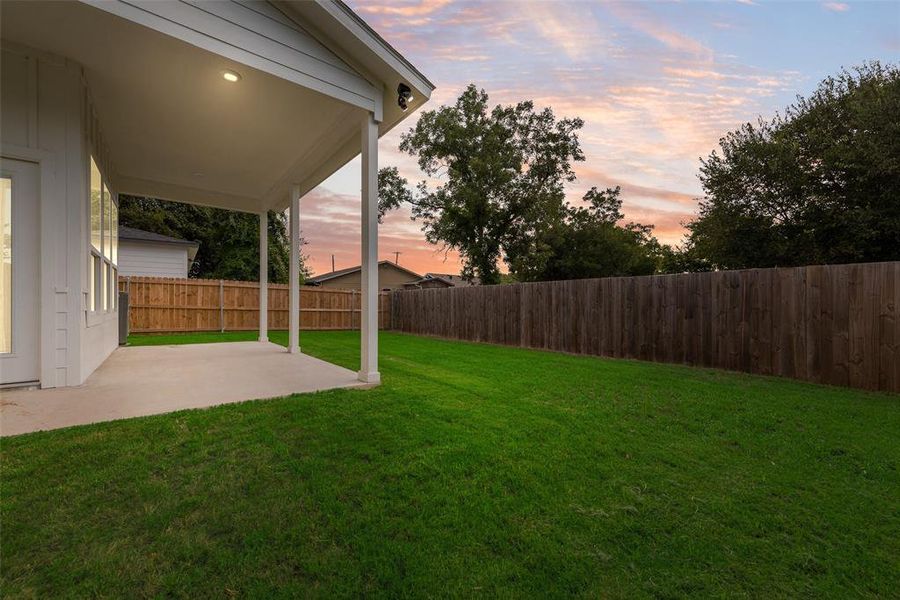 Fenced backyard with a patio area Fenced backyard with a patio area