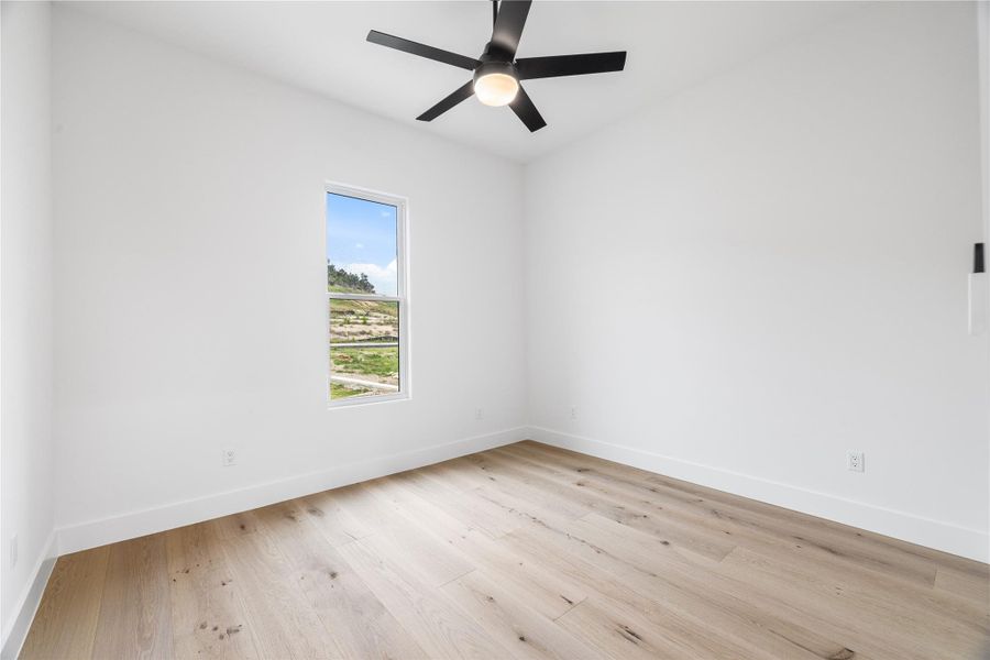 Guest bedroom featuring light wood-style floors and ceiling fan. Guest bedroom featuring light wood-style floors and ceiling fan.