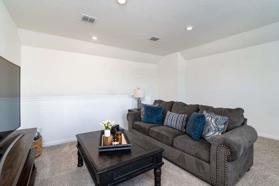 Living area featuring light carpet and recessed lighting