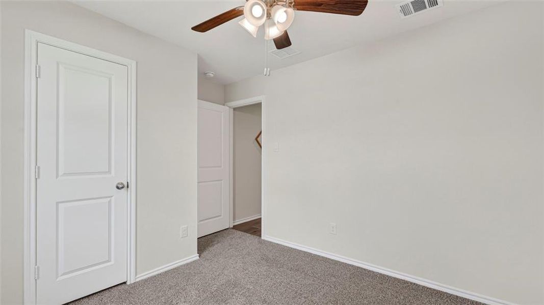 Interior room with light gray carpet, white baseboards, and light gray walls Interior room with light gray carpet, white baseboards, and light gray walls
