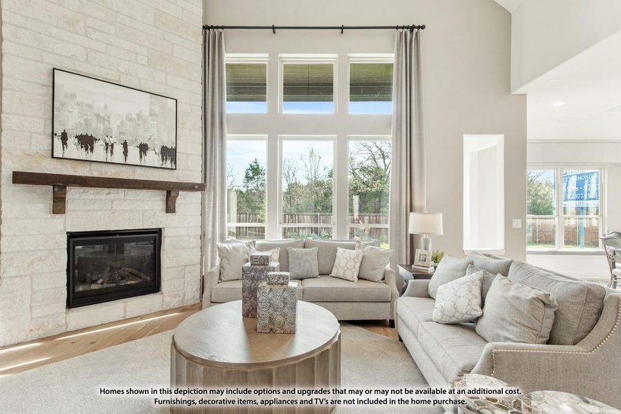 Living room with stone fireplace, high ceilings, large windows, and neutral gray sofas