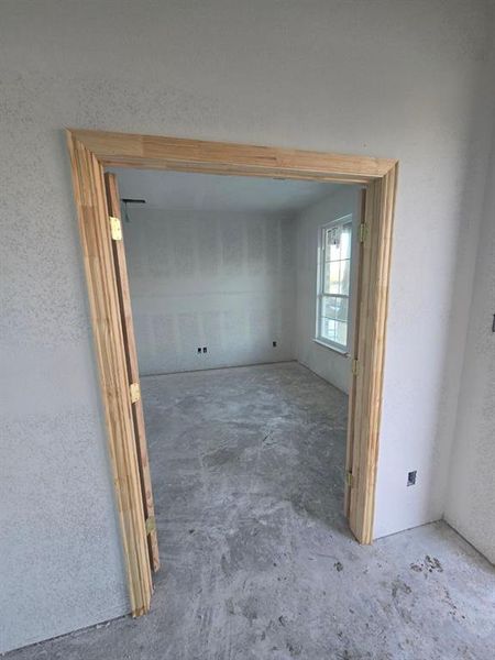 Unfurnished room featuring concrete flooring and a textured wall