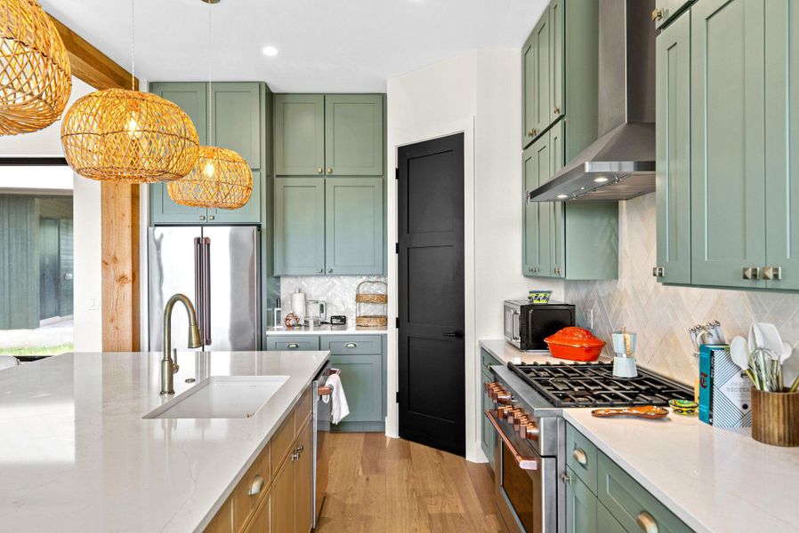 Gleaming stone countertops and matching cabinetry surround a modern island with clean architectural lines.