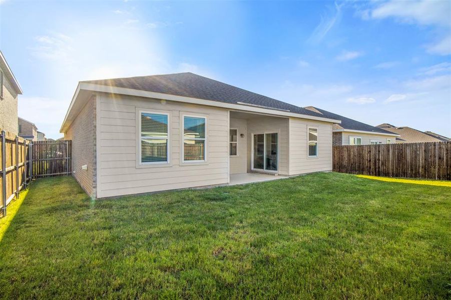 Rear view of property featuring a fenced backyard and a patio