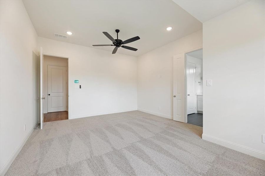 Carpeted spare room with ceiling fan